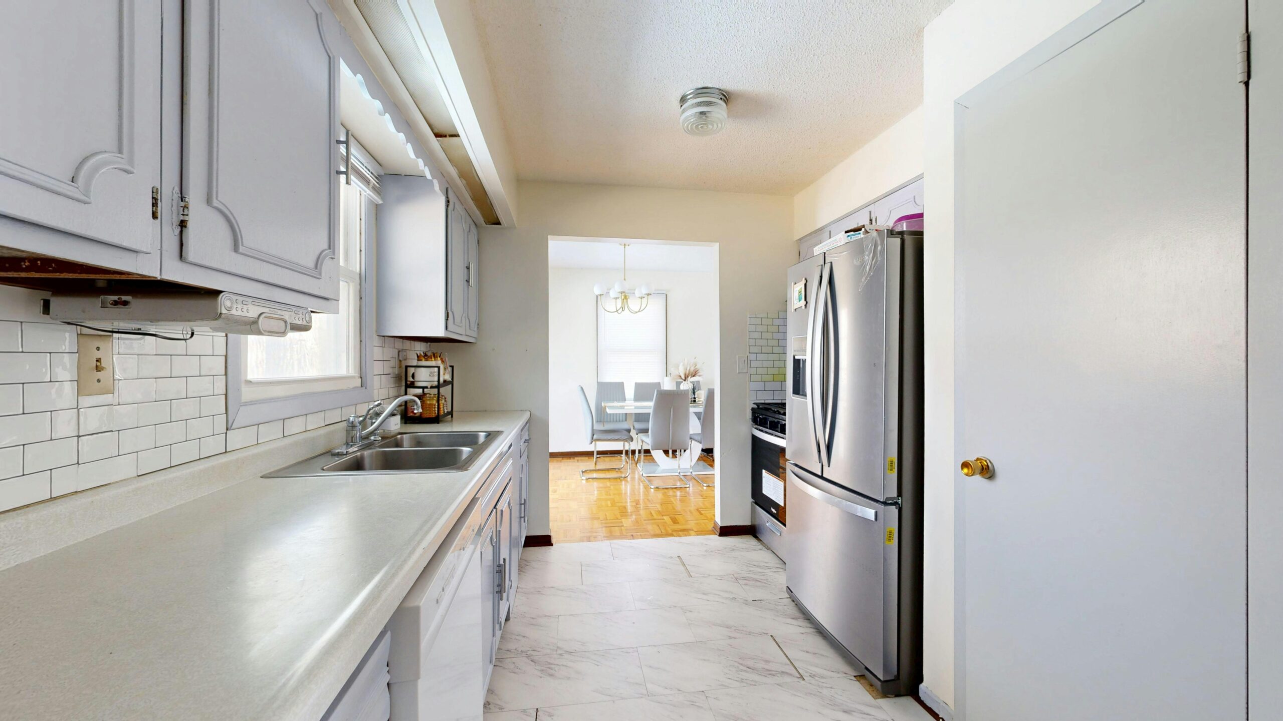 Bright kitchen with stainless steel appliances and dining area.